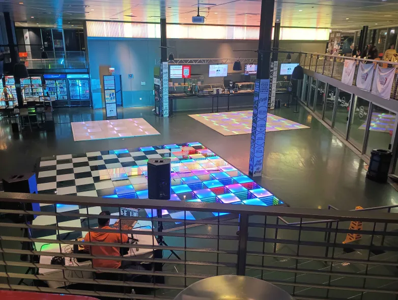 An overhead view of three empty dance floors. A DJ plays music for a crowd of none.